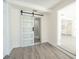 Bedroom with wood-look flooring features a modern barn door to closet and entry to bath at 7322 Mako Dr, Hudson, FL 34667