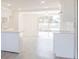 View of kitchen with white cabinets and peninsula counter top open to living space at 7322 Mako Dr, Hudson, FL 34667