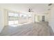 Large sun-filled living room boasts wood-look flooring and windows to backyard with privacy fence at 7322 Mako Dr, Hudson, FL 34667