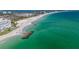 Aerial view of the beach with sparkling turquoise water and soft white sand at 8711 Blind Pass Rd # 207A, St Petersburg, FL 33706
