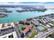 An aerial view shows condos by the inter coastal with community grounds, a pool, and tennis courts at 8711 Blind Pass Rd # 207A, St Petersburg, FL 33706