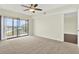 Bright bedroom featuring carpet and sliding glass doors leading to a balcony with a view of the community at 8711 Blind Pass Rd # 207A, St Petersburg, FL 33706