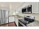 Modern kitchen with white cabinets, granite countertops, stainless steel appliances, and a view at 8711 Blind Pass Rd # 207A, St Petersburg, FL 33706