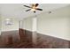 Cozy living room has dark hardwood floors, a ceiling fan, and a view into the kitchen at 8711 Blind Pass Rd # 207A, St Petersburg, FL 33706
