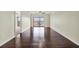 Spacious living room with gleaming hardwood floors, ceiling fan, and sliding glass doors to a balcony at 8711 Blind Pass Rd # 207A, St Petersburg, FL 33706