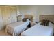 Serene bedroom with neutral tones features two twin beds and built-in closet storage at 9815 47Th N Ave # 306, St Petersburg, FL 33708