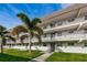 Condo building exterior showing well-manicured lawn and palm trees in front of units with balconies at 9815 47Th N Ave # 306, St Petersburg, FL 33708