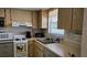 Efficient kitchen features white appliances, light wood cabinets, and durable countertops at 9815 47Th N Ave # 306, St Petersburg, FL 33708