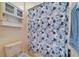 Full bath with blue floral shower curtain and built-in cabinet provides privacy and organized storage solutions at 10220 Deercliff Dr, Tampa, FL 33647