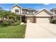 Beautiful two-story home featuring a well-manicured lawn, a two-car garage, and stone accents at 10220 Deercliff Dr, Tampa, FL 33647