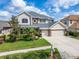 Charming two-story home with manicured lawn and stone accents on a sunny day with a clear blue sky at 10220 Deercliff Dr, Tampa, FL 33647