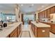 Bright kitchen with wood cabinets, tile floor, island, breakfast nook and view to the pool at 10220 Deercliff Dr, Tampa, FL 33647