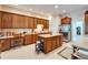 Bright kitchen with wood cabinetry, island, stainless refrigerator, tile floor, and desk area at 10220 Deercliff Dr, Tampa, FL 33647
