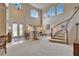 Spacious living room with a dramatic staircase, large windows, and traditional furnishings at 10220 Deercliff Dr, Tampa, FL 33647
