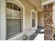 Inviting porch area with decorative stone pillar, a cozy white bench, and large windows at 10220 Deercliff Dr, Tampa, FL 33647