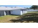 Backyard view showcasing the covered patio, well maintained lawn, and new exterior paint at 105 2Nd Ne Ave, Lutz, FL 33549
