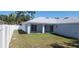 Backyard view showcasing the covered patio, lush green grass, and new exterior paint at 105 2Nd Ne Ave, Lutz, FL 33549