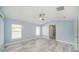 Bedroom featuring tile floors, a ceiling fan, two windows, and a walk-in closet at 105 2Nd Ne Ave, Lutz, FL 33549