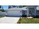 Charming single-story home featuring a manicured lawn and attached two-car garage at 105 2Nd Ne Ave, Lutz, FL 33549
