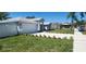Landscaped front yard with a long driveway leading to a well-maintained home at 105 2Nd Ne Ave, Lutz, FL 33549