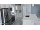 Bright kitchen featuring stainless steel appliances, white cabinets, and a large center island with a sink at 105 2Nd Ne Ave, Lutz, FL 33549