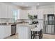 Bright kitchen featuring white cabinetry, stainless appliances and a granite-topped island at 1050 Davis Heather Cir, Seffner, FL 33584