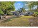Spacious backyard with lush green grass, a fire pit, and a home with an outdoor seating area at 108 S Lincoln Ave, Tampa, FL 33609