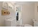 Bathroom with a white vanity and decorative mirror above leading to another room at 108 S Lincoln Ave, Tampa, FL 33609