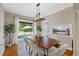 Dining room with rustic wood table, modern chandelier, and sliding doors to patio at 108 S Lincoln Ave, Tampa, FL 33609