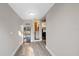 Hallway with gray plank flooring, view to bathroom and kitchen area with a bookshelf and white walls at 108 S Lincoln Ave, Tampa, FL 33609