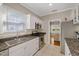 Well-lit kitchen featuring stainless steel appliances, granite countertops, and tiled floors at 108 S Lincoln Ave, Tampa, FL 33609