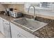 Kitchen sink with granite countertop, stainless steel appliances, and tile backsplash at 108 S Lincoln Ave, Tampa, FL 33609