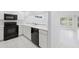 Bright kitchen features white cabinetry and black appliances at 12004 N 53Rd St, Temple Terrace, FL 33617