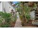 Charming brick-paved path through lush garden, featuring a decorative archway, blooming plants, and serene landscaping elements at 123 14Th Ne Ave, St Petersburg, FL 33701