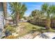 Private backyard with brick patio, mature trees, bench seating, and wooden fencing at 1366 Wexford N Dr, Palm Harbor, FL 34683