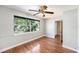 Cozy bedroom with wood floors, a ceiling fan, and a large window with natural light at 1366 Wexford N Dr, Palm Harbor, FL 34683