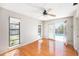 Bright bedroom with wood floors, ceiling fan, and sliding door access to the outdoor pool area at 1366 Wexford N Dr, Palm Harbor, FL 34683