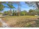 Expansive front yard featuring mature trees and green grass, offering curb appeal for this home at 1366 Wexford N Dr, Palm Harbor, FL 34683