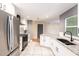 Bright kitchen with stainless steel refrigerator, granite counters, and white cabinets at 1366 Wexford N Dr, Palm Harbor, FL 34683