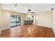 Bright, open living area featuring wood floors, a ceiling fan, and sliding glass door access to the backyard at 1366 Wexford N Dr, Palm Harbor, FL 34683