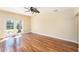 Open-concept living room with wood floors, ceiling fan, and sliding glass doors at 1366 Wexford N Dr, Palm Harbor, FL 34683