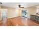 Open living space with wood floors, ceiling fan, sliding doors to the patio, and pass-through bar at 1366 Wexford N Dr, Palm Harbor, FL 34683