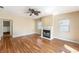 Cozy living room featuring wood floors, fireplace, ceiling fan, and lots of natural light at 1366 Wexford N Dr, Palm Harbor, FL 34683