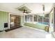 Enclosed sunroom with ceiling fan, access to backyard pool and green painted accents at 1366 Wexford N Dr, Palm Harbor, FL 34683