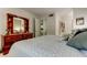 Bright bedroom with a dresser, closet, and a glimpse into the hallway and kitchen at 14130 Rosemary Ln # 1201, Largo, FL 33774
