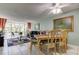 Bright dining room featuring an elegant table, ceiling fan, and a large window view into the living room at 14130 Rosemary Ln # 1201, Largo, FL 33774