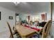 Bright dining room with a light wood table, leading to a living area with large windows at 14130 Rosemary Ln # 1201, Largo, FL 33774