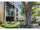 Beautiful building exterior with mature trees, manicured lawn, and a white fence at 14130 Rosemary Ln # 1201, Largo, FL 33774