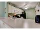 A kitchen with white cabinets, black appliances, and lots of natural light shining on white counters at 14130 Rosemary Ln # 1201, Largo, FL 33774