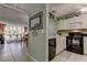 A view of the kitchen and the living area, featuring white cabinets and black appliances at 14130 Rosemary Ln # 1201, Largo, FL 33774
